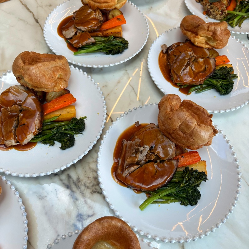 Lamb roast dinner dish served with Yorkshire puddings on crockery plates.